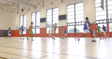 Okulun spor salonunda basketbol oynamak, üniformalı öğrencilerin oyun becerileri çalışması. Spor, takım çalışması, egzersiz, fitness, rekabet, pratik