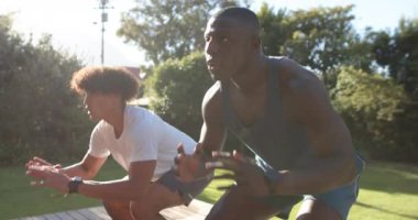 Açık havada egzersiz yaparken, iki çok ırklı erkek arkadaş parkta çömeliyor, egzersiz yapıyor, fotokopi çekiyor. fitness, egzersiz, sağlık, sağlık, takım çalışması, eğitim
