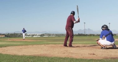 Beyzbol oynuyor, bordo üniformalı vurucu sahada atış yapmaya hazırlanıyor. Sporcu, spor, yarışma, açık hava, oyun, hazırlık