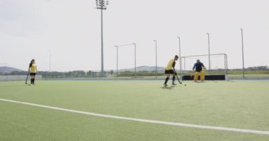 Kadın hokey oyuncusu sahada antrenman yapıyor, kaleci blok atışı için dalıyor. Spor, atletizm, rekabet, uygulama, eylem, takım çalışması