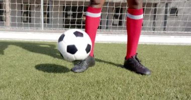 Futbol sahasında kırmızı çoraplarıyla futbol topuna basan Afro-Amerikan erkek oyuncu. Futbol, Afro-Amerikan erkek atlet, spor, oyun, takım çalışması, yarışma