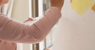 Yaşlı kadın evde resim yapıyor, Noel boyunca yaratıcı yalnızlığın tadını çıkarıyor. Yaşlılar, yaratıcılık, tatil, şenlik, eğlence