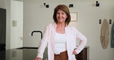 Modern mutfakta duran, kıdemli kadın bayram yemeği hazırlarken gülümsüyor. Yemek pişirme, şenlik, aşçılık, mutluluk, hazırlık, aile