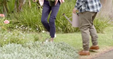 Olgun çiftler birlikte bahçeyle uğraşıyorlar, doğanın tadını çıkarıyorlar ve dışarıda çiçeklerle ilgileniyorlar. Bahçıvanlık, takım çalışması, yaşam tarzı