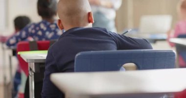 Okulda, öğrenciler sıralarında oturuyor ve sınıfta bayan öğretmenleri dinliyor. Eğitim, öğrenme, öğretim, akademik, konferans