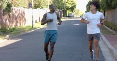 İki çok ırklı erkek arkadaş banliyöde el sıkışarak ve kucaklaşarak birbirlerini selamlıyorlar. Arkadaşlık, açık hava, gündelik, neşeli, bağlantı, yaşam tarzı