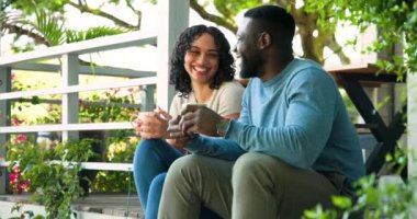 Verandada dinlenen Afro-Amerikalı çift dışarıda kahve içip sohbet ediyorlar. Rahatlama, bağlanma, rahatlama, yaşam tarzı, birliktelik.