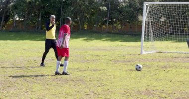 Futbol oynuyor, kırmızı üniformalı oyuncu kaleye doğru koşuyor. Spor, atlet, yarışma, aksiyon, takım çalışması, skor