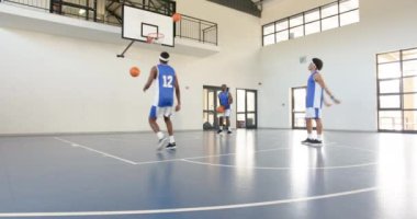 Basketbolcular spor salonundaki kapalı sahada atış talimi yapıp salyalarını akıtıyorlar. Spor, sporcular, antrenman, yarışma, takım çalışması, egzersiz
