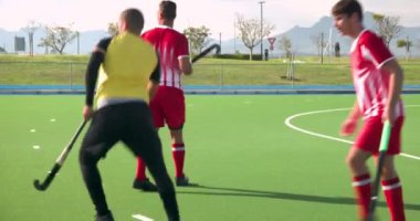 Çim hokeyi oynuyorlar, erkek oyuncular dışarıda sahada, üniforma giyiyorlar. Spor, takım, yarışma, sporcular, oyun, egzersiz