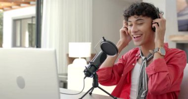 Podcast kaydı, kulaklıkları ve mikrofonuyla gülümseyen genç çocuk. Podcasting, teknoloji, ev ofisi, ses, yayın, ekipman