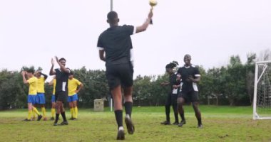 Zaferi kutlayan siyah üniformalı futbol takımı sahada kupa tutuyor. Kutlama, galibiyet, şampiyonlar, spor