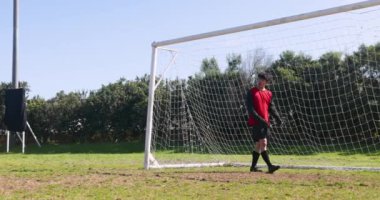 Kale direğinin önünde duran futbolcu sahada kırmızı forma giyiyor. atlet, spor, yarışma, takım, futbol
