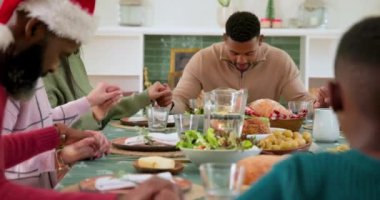 Noel 'de, çeşitli aileler el ele tutuşup evdeki şenlikli yemek masasında şükranlarını sunuyorlar. Kutlama, Şükran Günü, birliktelik, gelenek, minnettarlık, ziyafet