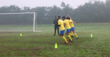 Futbolcular sahada antrenman yaparken koç gözlemliyor ve yol gösteriyor. pratik, takım çalışması, antrenman, spor, açık hava, spor