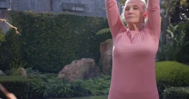 Yoga yapıyorlar, çok ırklı bayan arkadaşlar dışarıda meditasyon yapıyorlar. Huzurlu bir bahçe ortamında. Sağlık, farkındalık, meditasyon, fitness, rahatlama, sağlıklı