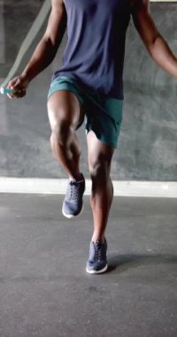 Dikey video: İp atlama, spor salonunda egzersiz yapan atletik adam, dayanıklılık ve dayanıklılık. Fitness, egzersiz, kardiyo, antrenman, egzersiz, vücut geliştirme