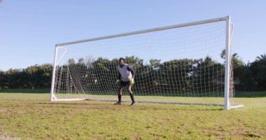 Kaleci iş başında, futbol kalesinin önünde duruyor, savunmaya hazır. Spor, yarışma, atlet, defans, maç, saha