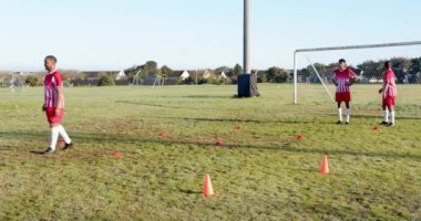 Futbol oynamak, sahada külahlarla ve kale direkleriyle antrenman yapmak. Spor, takım çalışması, egzersiz, eğitim, açık hava, spor