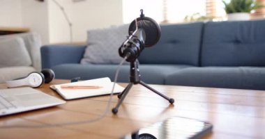 Podcast, dizüstü bilgisayarlı mikrofon, kulaklık ve not defteri, evde. Podcasting, broadcasting, audio, equipment, technology, workspace