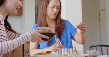 Birlikte yemek yiyorlar, Asyalı anne ve kız evde yemek masasında çubuklarla yemek yiyorlar. Arkadaşlar, birliktelik, bağlanma, keyif, aşçılık