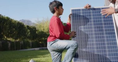 Güneş paneli, Hintli baba ve oğul açık havada yenilenebilir enerjiyi tartışıyorlar. çevre, sürdürülebilirlik, aile, teknoloji, bağlanma, gelecek