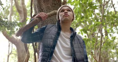 Genç adam doğanın tadını çıkarıyor. Huzurlu orman ortamında ağaca yaslanıyor. Rahatlama, yalnızlık, sükunet, sükunet, dinginlik, yeşillik