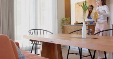 Vazo ve içecekle masayı hazırlamak, genç Asyalı genç kız evde yemek için hazırlanıyor. Yemek, hazırlık, yerli, yaşam tarzı, ev yapımı, iç mekan