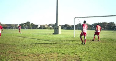 Futbol oynuyor, kırmızı üniformalı erkek oyuncular maç sırasında sahada. Spor, rekabet, takım çalışması, atletik, aksiyon