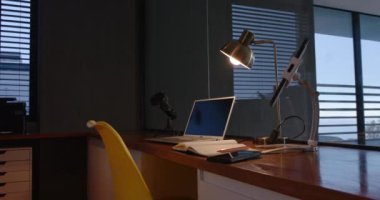 Laptop ve akıllı telefon, ofis kurulumunda defter ve lambayla birlikte masanın üzerinde. İş yeri, üretkenlik, teknoloji, modern, çalışma alanı, organize