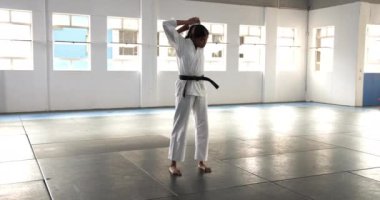 Judo çalışıyorum, beyaz giysili adam dojo 'da paspasın üzerinde duruyor. Dövüş sanatları, eğitim, kendini savunma, disiplin, dövüş
