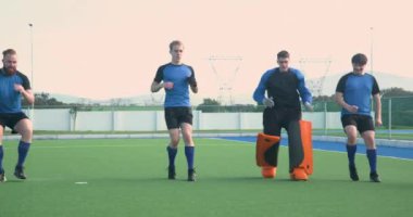 Erkek hokey oyuncuları sahada koşuyor, antrenmana hazırlanıyorlar. Spor, egzersiz, takım çalışması, fitness, antrenman, hazırlık