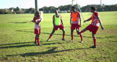 Esniyor ve ısınıyor, erkek futbolcular sahada antrenmana hazırlanıyor. Sporcular, antrenman, fitness, spor, egzersiz, takım çalışması