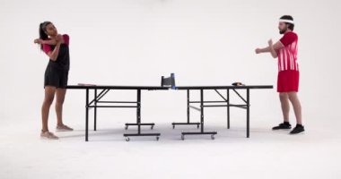 Masa tenisi oynuyorlar, kadın ve erkek yoğun bir maçta karşı karşıya. Spor, rekabet, ping pong, yoğunluk, atletik, eğlence