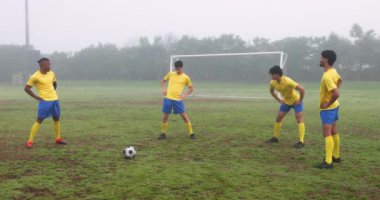 Futbolcular sisli bir günde maçtan önce sahada ısınıp ısınıyorlar. Spor, futbol, antrenman, egzersiz, spor, hazırlık.