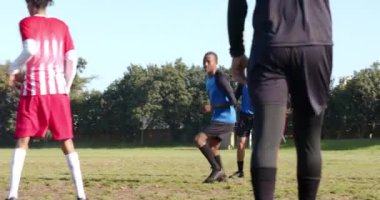 Futbol oynuyor, kırmızı üniformalı takım kaleye doğru koşuyor, kaleci hazır. Takım sporları, müsabakalar, atletler, kalecilik, takım çalışması, sportmenlik