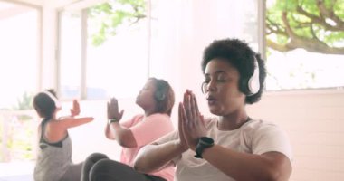 Afro-Amerikalı kadınlar kulaklıklarla meditasyon yapıyorlar, birlikte huzur ve rahatlama buluyorlar. Meditasyon, farkındalık, sağlık, müzik, sükunet, sükunet