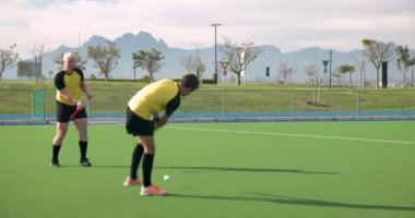 Çim hokeyi oynuyorlar, erkek oyuncular yeşil sahada mücadele ediyorlar. Spor, rekabet, takım çalışması, sporcular, aksiyon, fitness