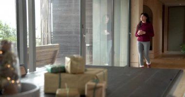 Pencere kenarında sıcak içecekten hoşlanan, evinde rahat çoraplar giyen, fotokopi çeken bir kadın. Rahatlama, sükunet, kapalı alan, yaşam tarzı, sıcaklık, rahatlık.