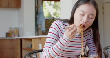 Yemek çubuklarıyla erişte yemek, Asyalı anne ve kız birlikte yemek yiyorlar. birliktelik, arkadaşlık, mutfak, keyif, Asya, kültür