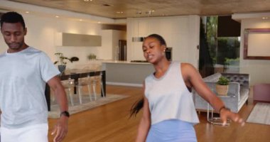 Yoga pratiği yapan, genç Afrikalı Amerikalı çift modern oturma odasında birlikte geriniyor. Zindelik, sağlık, egzersiz, rutin, yaşam tarzı, esneklik