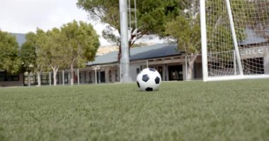 Futbol topunu kaleye doğru fırlatıyor, Afrikalı Amerikalı erkek oyuncu sahada, kopyalama alanında antrenman yapıyor. Futbol, Afro-Amerikan erkek sporcu, antrenman, eğitim