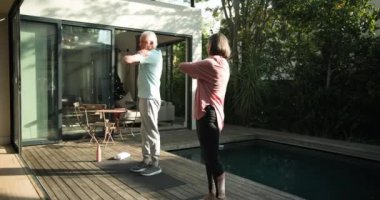 Üst düzey çift güneşli bahçe ortamında birlikte egzersiz yapmayı seviyor. Yaşlılık, spor, sağlık, sağlıklı yaşam tarzı, aktif, açık hava.