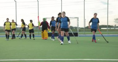 Kadın hokey takımı sahada strateji kuruyor, rekabet maçına hazırlanıyor. Takım çalışması, sporcular, spor, kadınlar, rekabet, strateji