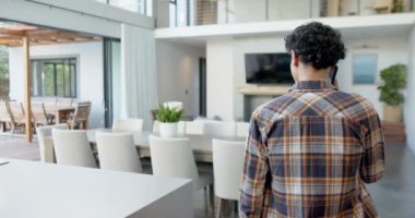 Modern oturma odasına bakıyorum, ekose gömlekli genç çocuk ev dekoruna hayran. İç mekan, yaşam tarzı, hayranlık, trendler, konfor, tasarım