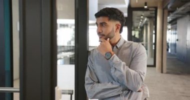 Derinden düşünen iş adamı modern ofis koridorunda duruyor. kurumsal, profesyonel, düşünceli, yönetici, girişimci