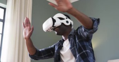 Evde sanal gerçeklik dünyasını keşfetmek için VR kulaklık kullanan Afrikalı Amerikalı bir adam. teknoloji, oyun, dalgın, fütüristik, yenilik, eğlence