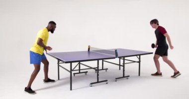 Masa tenisi oynuyorlar, iki adam içeride hızlı bir maç yapıyorlar. Spor, rekabet, ping pong, aktivite, sporcular, dinamik