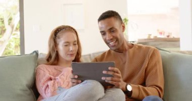 Çeşitli çiftler evde tablet kullanıyor, tatilin tadını çıkarıyorlar. Teknoloji, yaşam tarzı, bağlantı, mutluluk