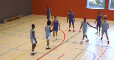 Basketbolcular spor salonunda takım çalışması yapıyor ve oyun sırasında strateji geliştiriyor. Spor, antrenman, sporcular, yarışma, egzersiz